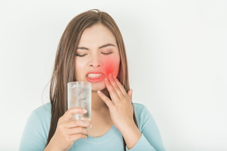 Sensitive teeth in woman And a glass of cold water