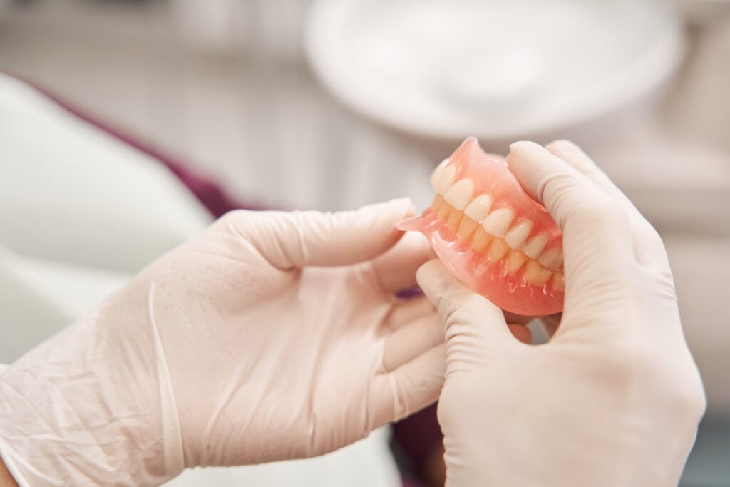 Dentist holding dentures in her hands